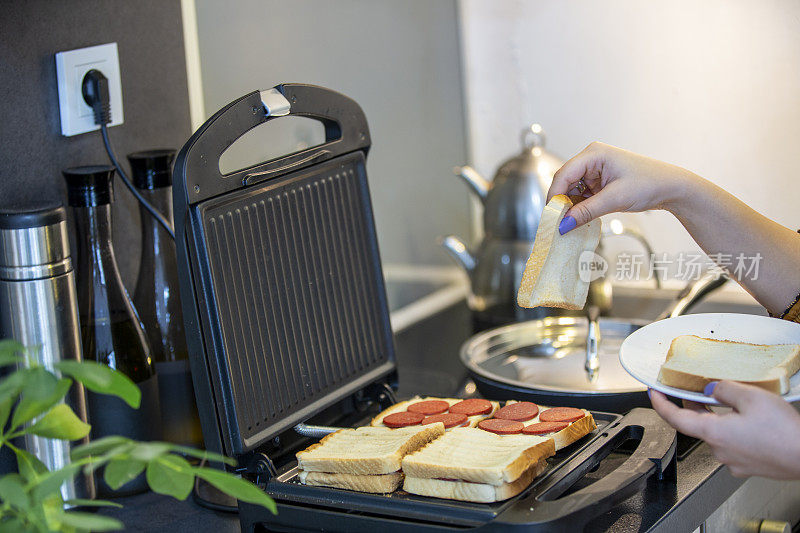 在厨房用烤面包机准备早餐
