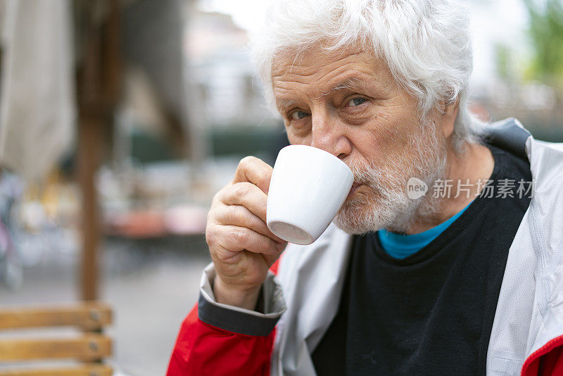 帕金森病患者在餐厅喝咖啡的肖像。