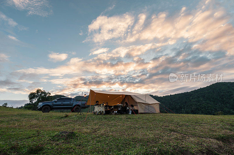 一群朋友晚上在乡间的小山上和大帐篷里放松