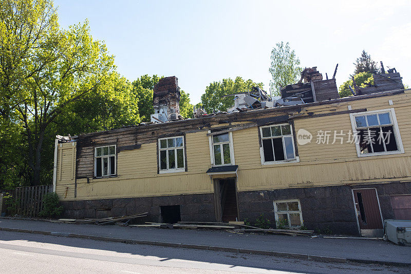 在芬兰的城市街道上，一座木头房子被大火烧毁，成为了一座建筑的废墟。