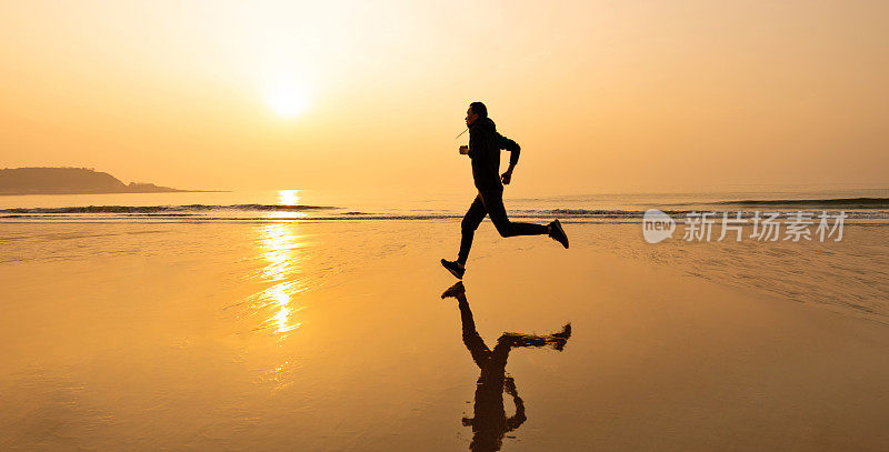 男人在金色的沙滩上奔跑