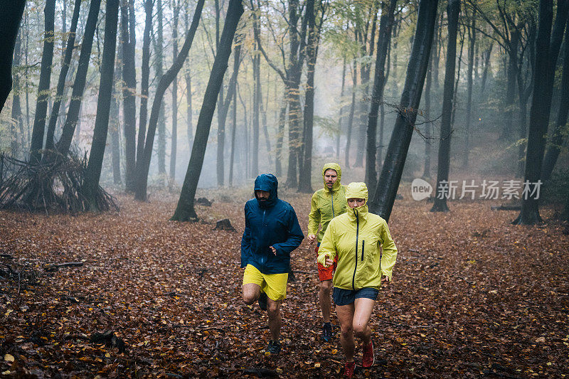 跑步者在雨天穿过森林