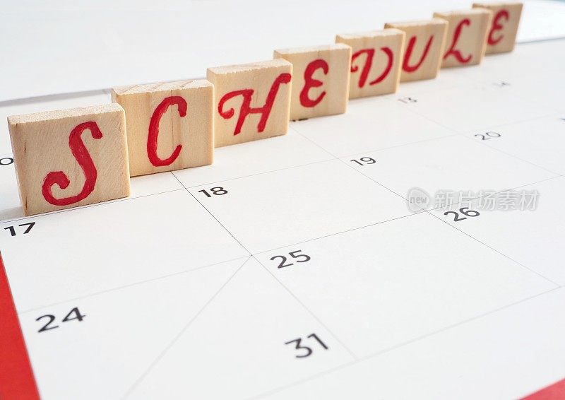 在白色日历上用木块斜着写着日程表，日程表的末尾变得模糊起来