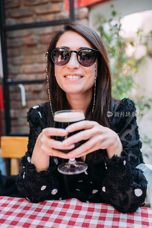 在啤酒厂酒吧外喝啤酒的女人
