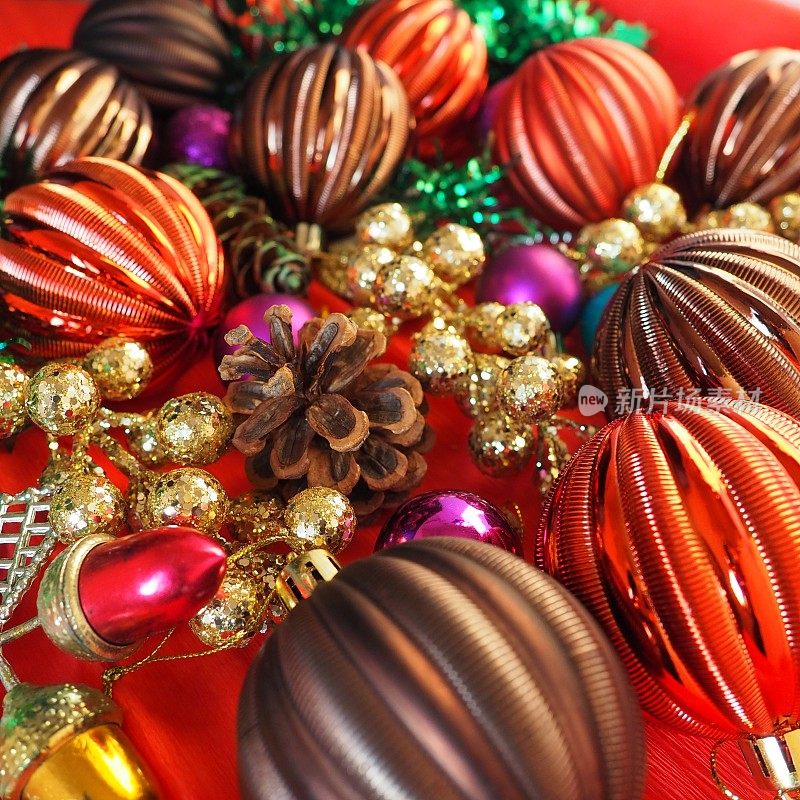 圣诞背景与圣诞装饰，节日球，铃铛，蝴蝶结，冷杉锥，圣诞树雨。新年快乐，圣诞快乐。红色，棕色，条纹，绿色，金色，紫色，五颜六色的装饰