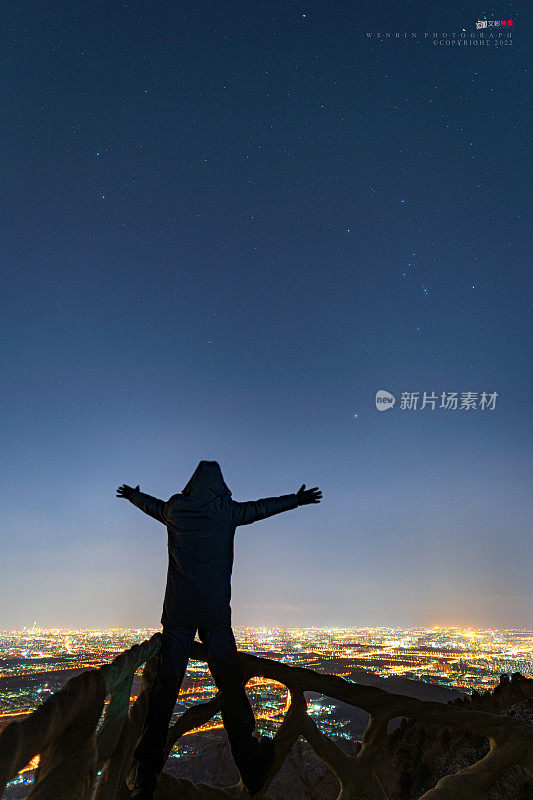 一个男人站在城市的夜景上
