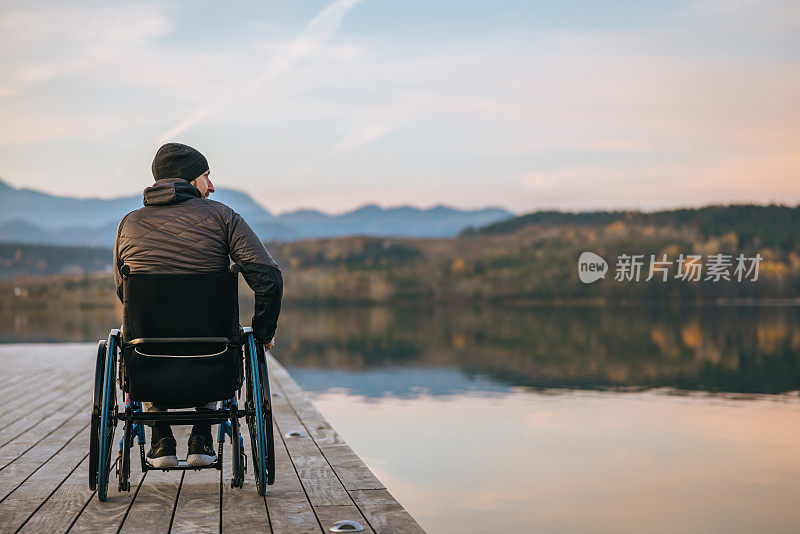 坐在轮椅上的人在码头上欣赏日落