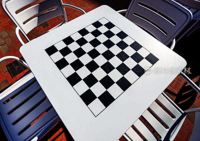 黑色和白色的国际象棋和跳棋棋盘上的银色金属桌