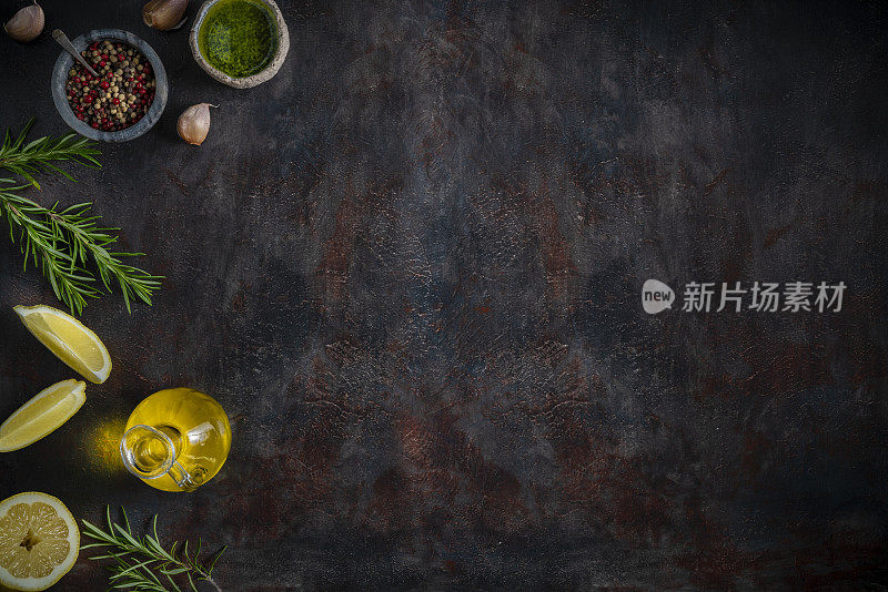 食品拷贝空间背景与柠檬，橄榄油，胡椒，大蒜迷迭香上深灰色
