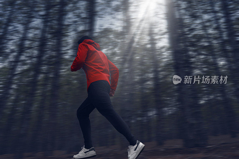 男子在森林中奔跑的侧视图拍摄