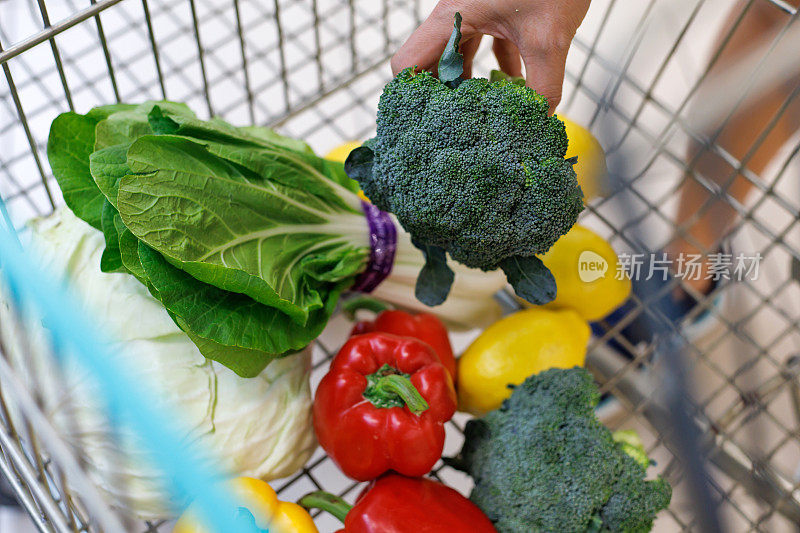 特写手放置新鲜的有机水果和蔬菜在购物手推车