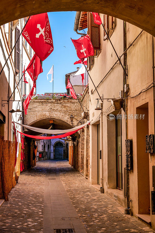 在中世纪的Foligno小镇，几十面带有纹章符号的旗帜装饰着一条小巷