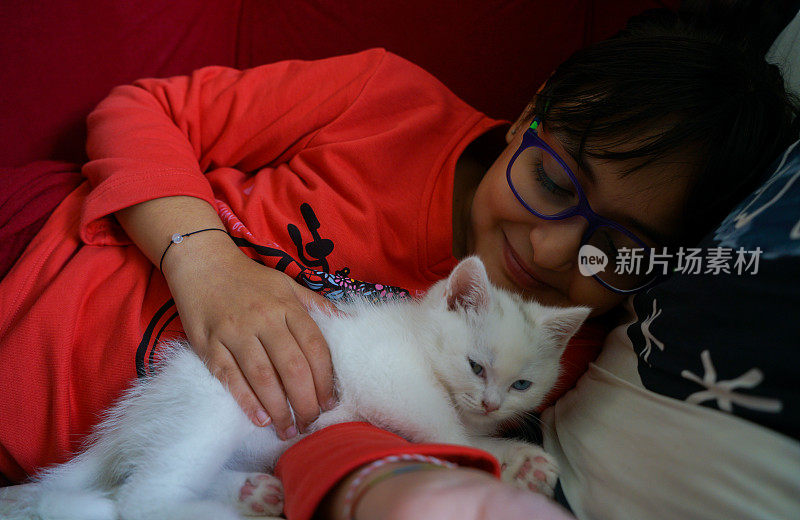 小猫和小女孩躺在床上