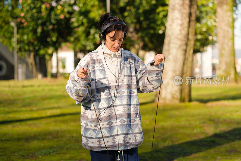 女子在公园边听音乐边跳绳