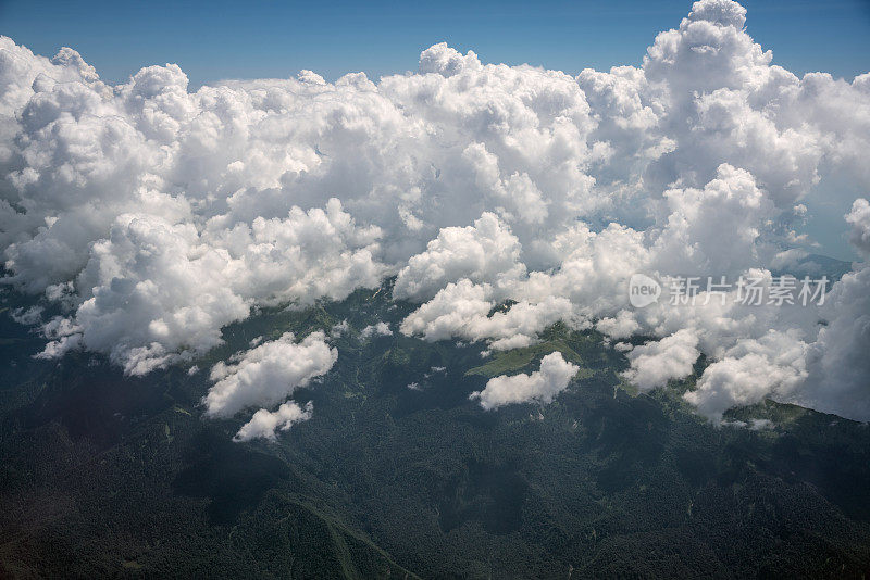 从飞机视角鸟瞰山脉上空的巨大云层
