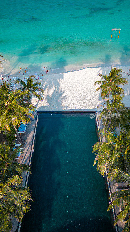 马尔代夫游泳池在热带岛屿度假酒店海滩与空中无人机视图