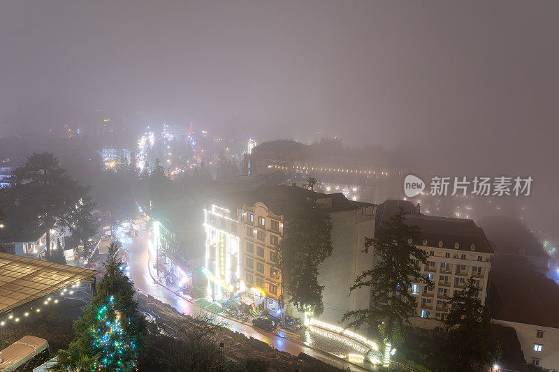 越南萨帕的夜生活，游客和当地人在晚上走在萨帕中心的广场上，雾蒙蒙的夜晚和潮湿的街道。