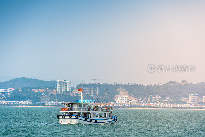 越南广宁省下龙湾景观;有很多石灰岩小岛和游轮;在一个蓝天的夏日