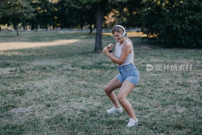 一位年轻女子正在公园里准备晨练。