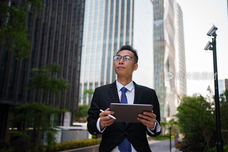 一名男子在大楼外使用平板电脑