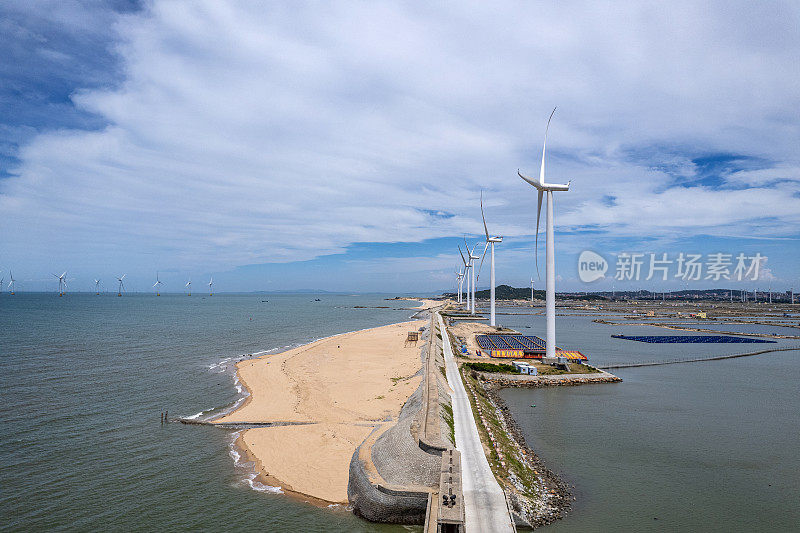 在海边阳光明媚的海滩上，风力涡轮机的鸟瞰图