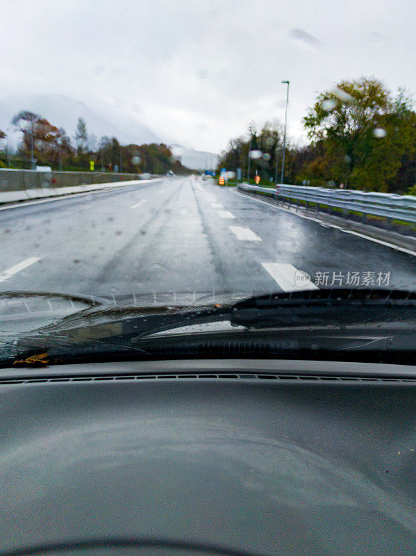 雨天驾车行驶在高速公路上的驾驶员透过挡风玻璃看到的湿路