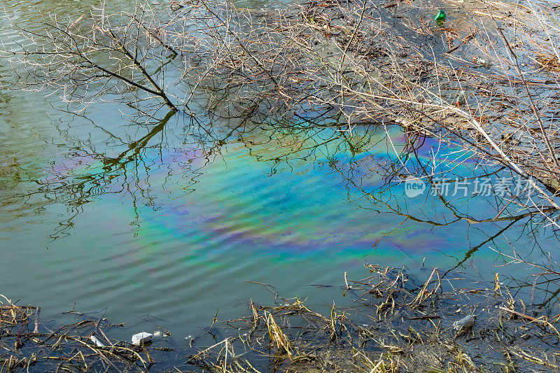 这条河的地表水上有一层彩色的油膜，这是石油或汽油污染的结果。环境污染问题