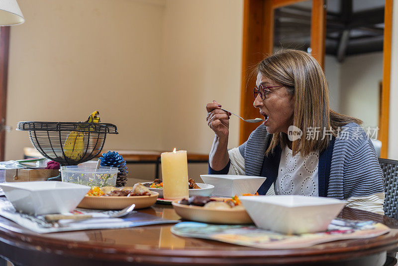 一位拉丁妇女在养老院里负责照顾她，吃着照顾她的人准备的美味午餐