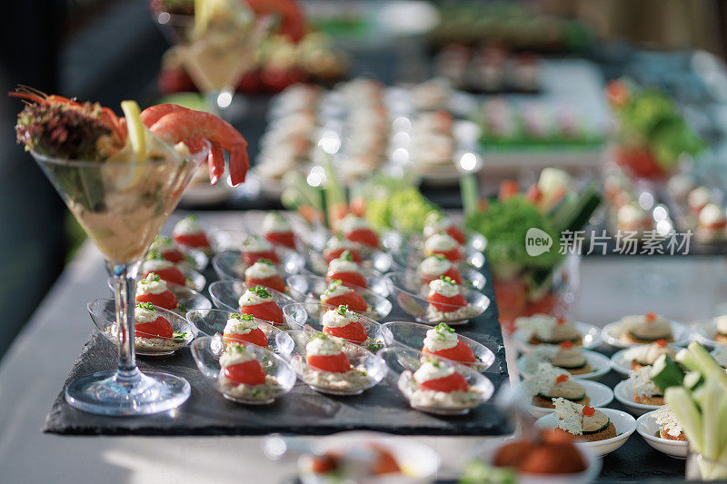 各种甜点，开胃菜，和手指食物安排在自助餐桌上，为聚会客人准备享受。