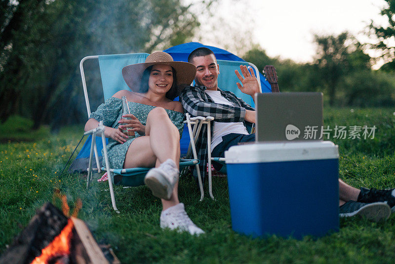 一对年轻夫妇正在露营时进行视频通话。