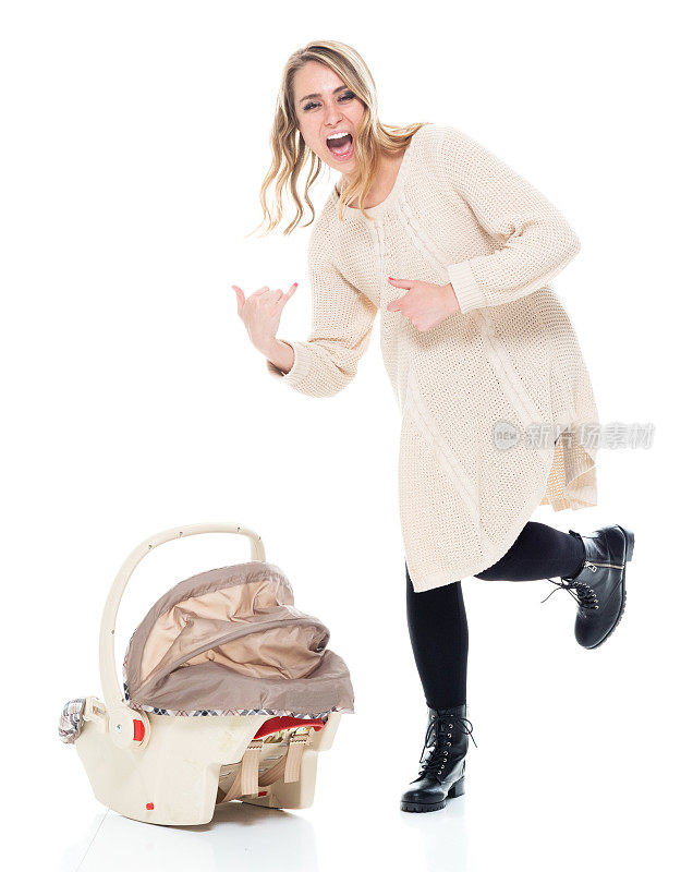 单身妈妈穿着一件带有婴儿汽车座椅的毛衣，空气吉他