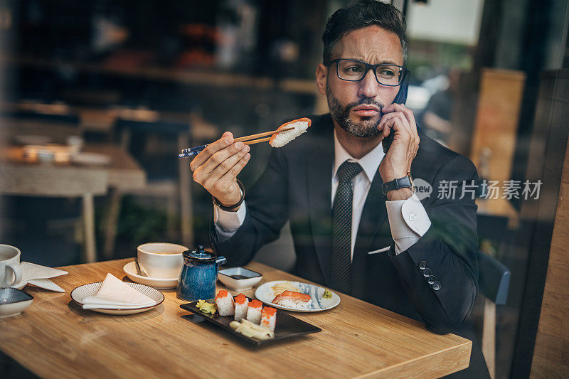 在寿司店打电话的男人