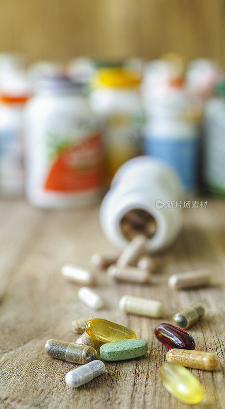 许多营养保健品和维生素都以胶囊、片剂为背景，以其药瓶为背景，聚焦深度较浅。