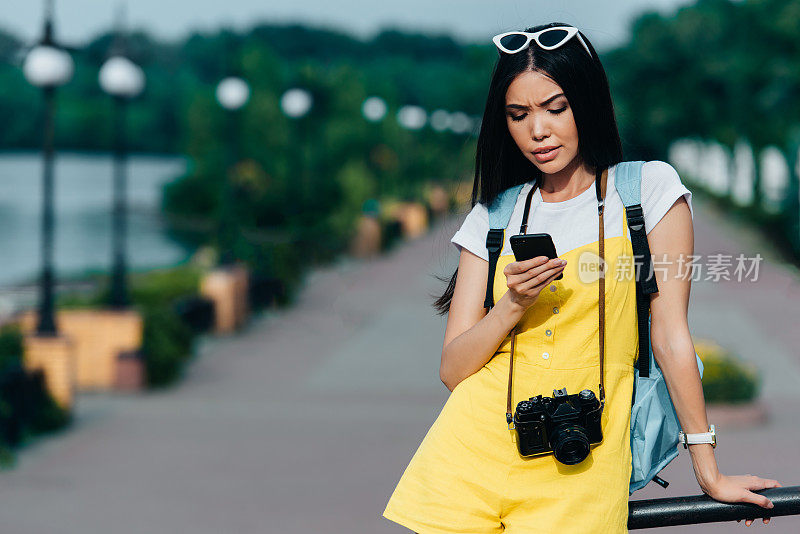 亚洲和迷人的女人在看智能手机