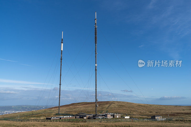 在晴朗的天空下，通信塔矗立在荒原上