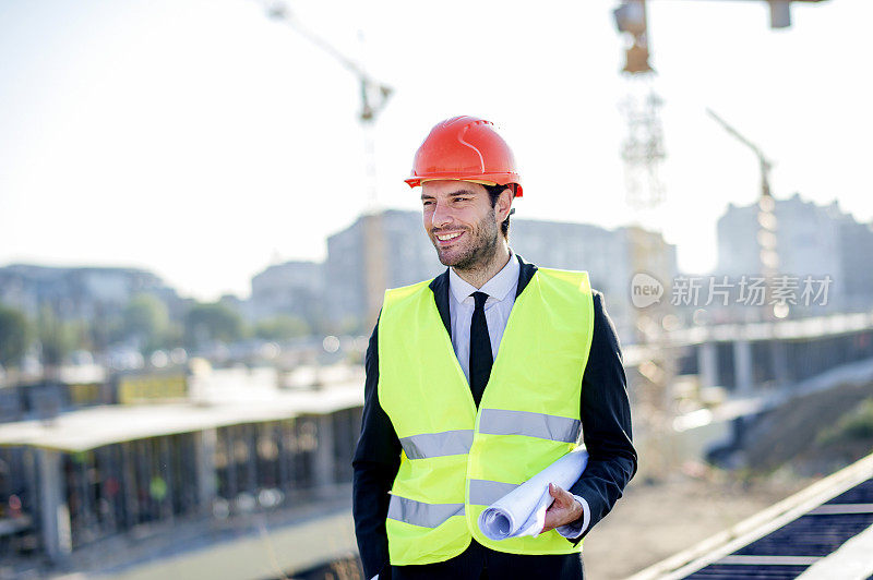 年轻的建筑工程师带着工程和安全帽