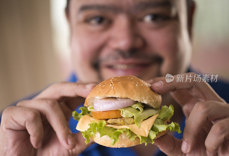 一个正在吃快餐汉堡的男人