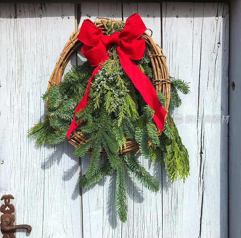 绿色的圣诞花环，红色的蝴蝶结，乡村的门