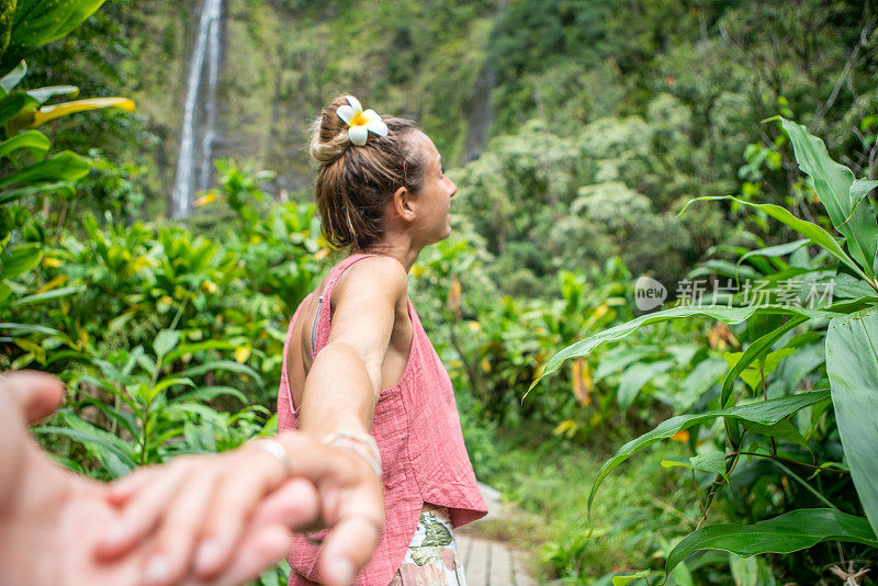 跟随我的概念-年轻女子带领男友到热带雨林和瀑布