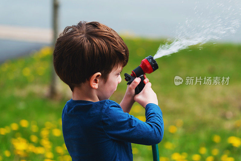 男孩为家花园浇水