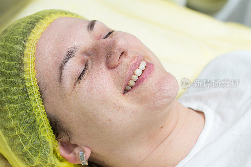 一个快乐的女人躺在美容院里。