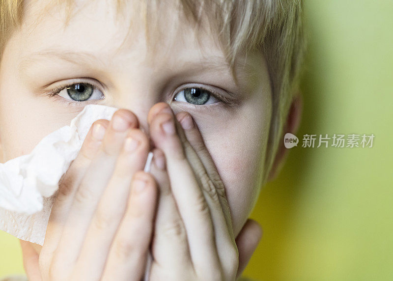 一个生病的男孩在擦鼻子