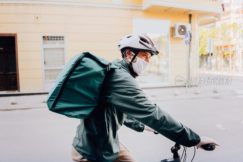 快递员骑着自行车穿过城市