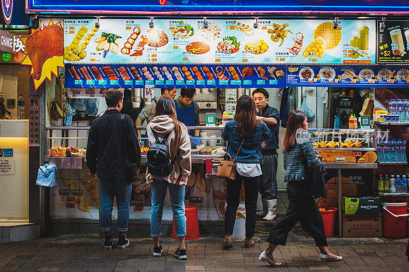 人们晚上在香港街头买食物，