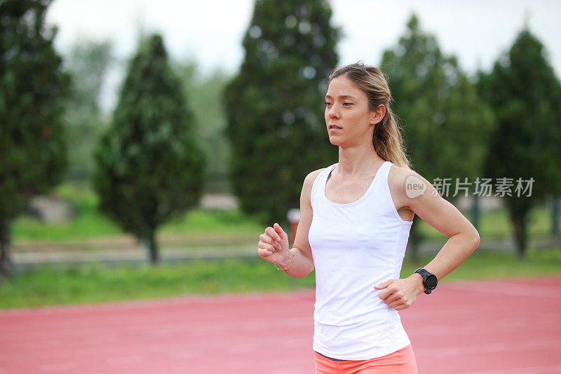 女子短跑运动员在体育场跑步。