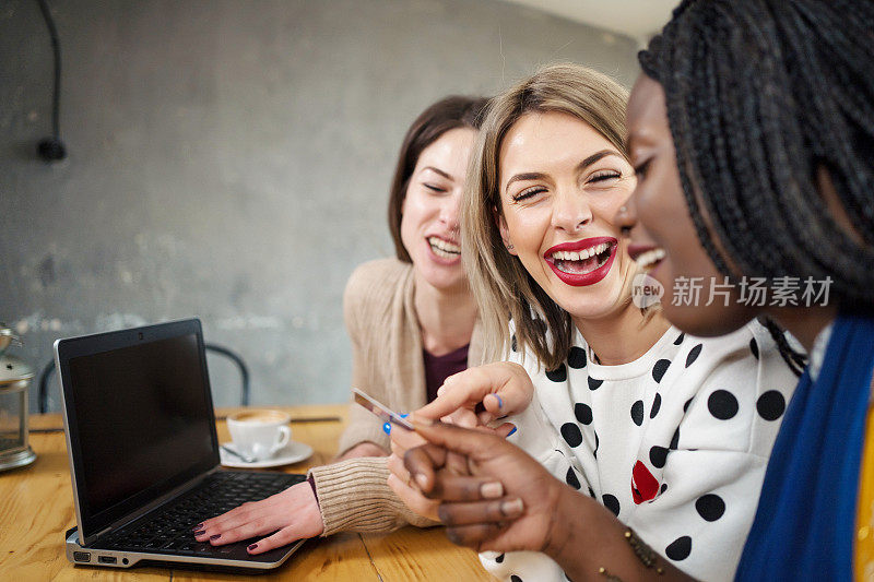 美丽的年轻女子多民族妇女在网上购物的咖啡馆