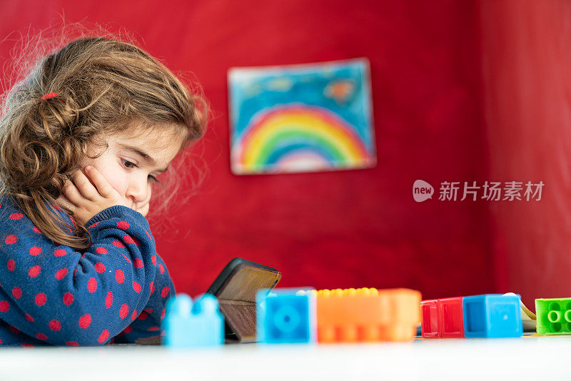 小女孩用智能手机看学前教育视频的肖像