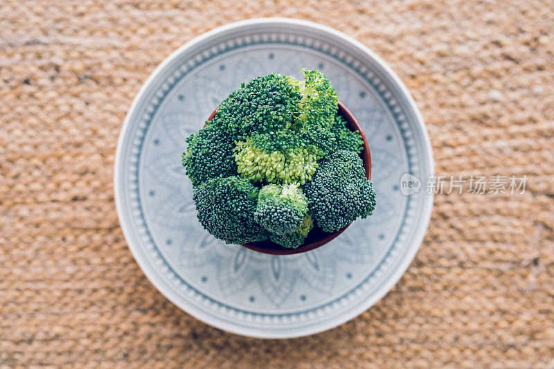 以树莓为背景，盘上碗里的花椰菜