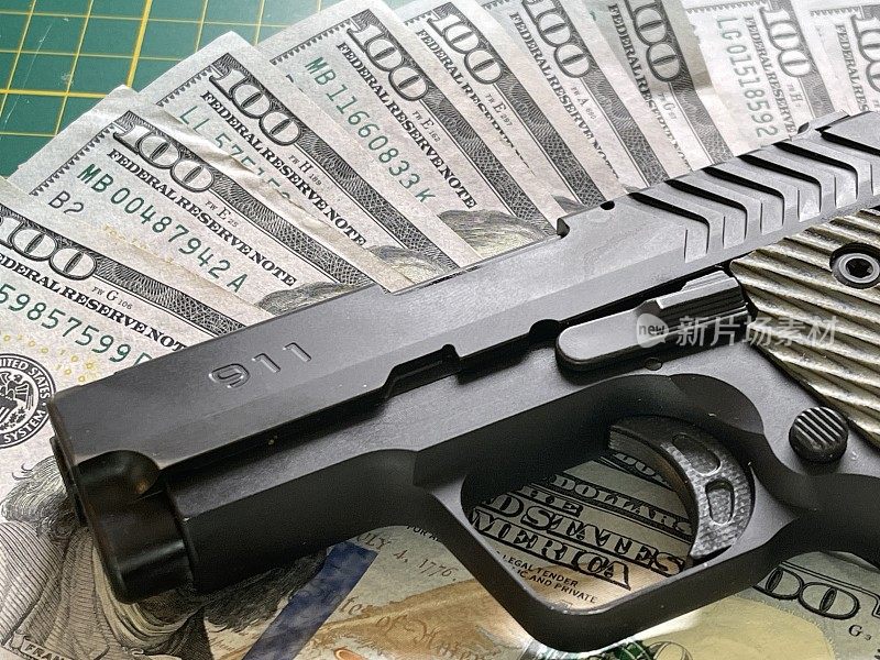 九毫米手枪和扇形百元钞票表明有犯罪活动