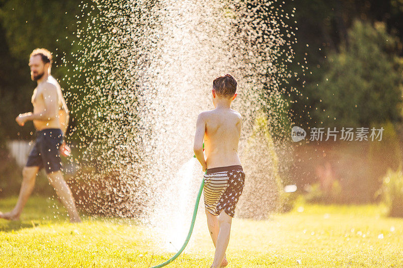 父亲和儿子在后院玩水